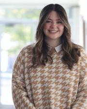 Abby Riffel wearing an orange and white dress shirt.